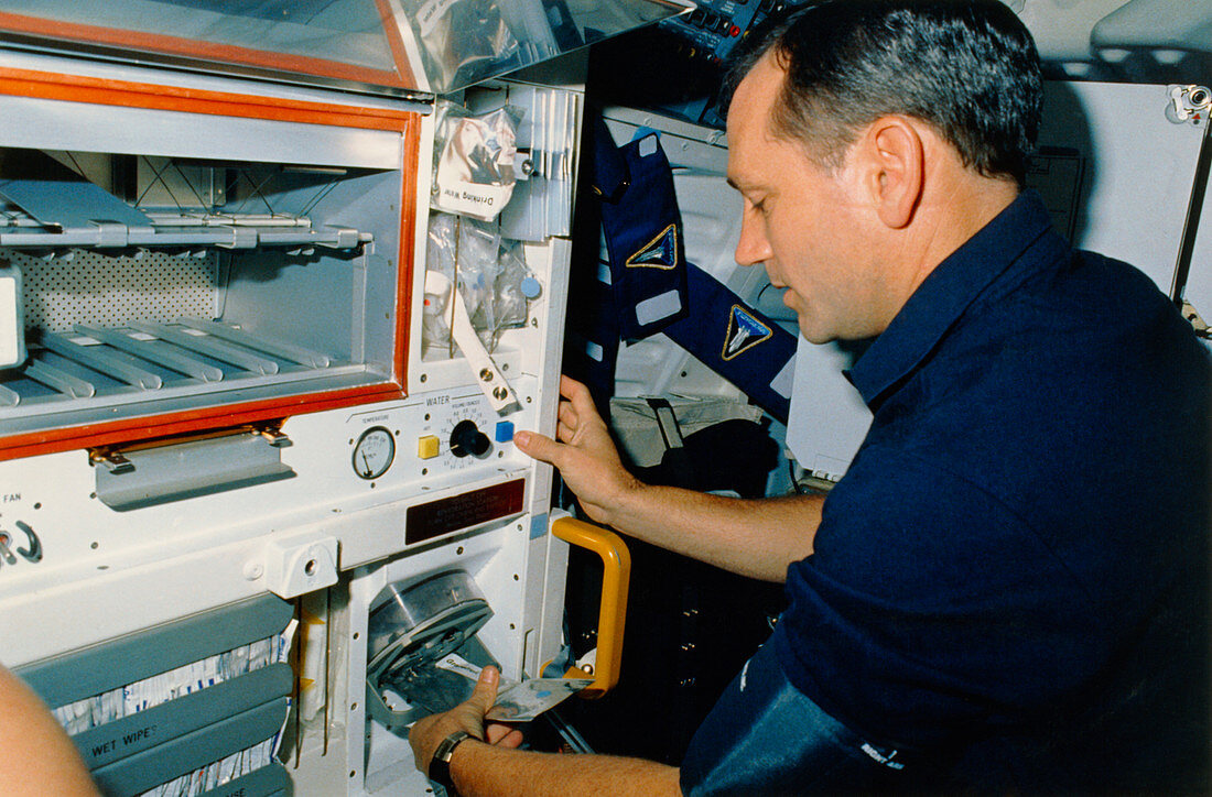 Astronaut Akers rehydrating food package