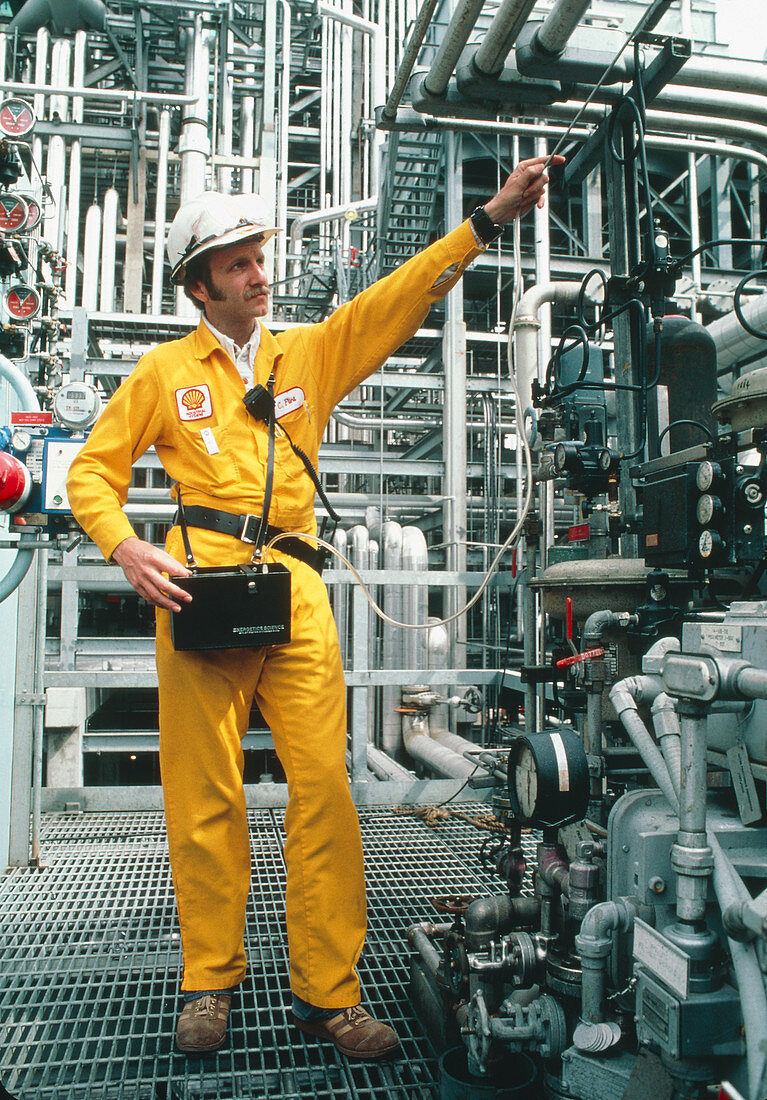 Technician tests gas piping at an oil refinery