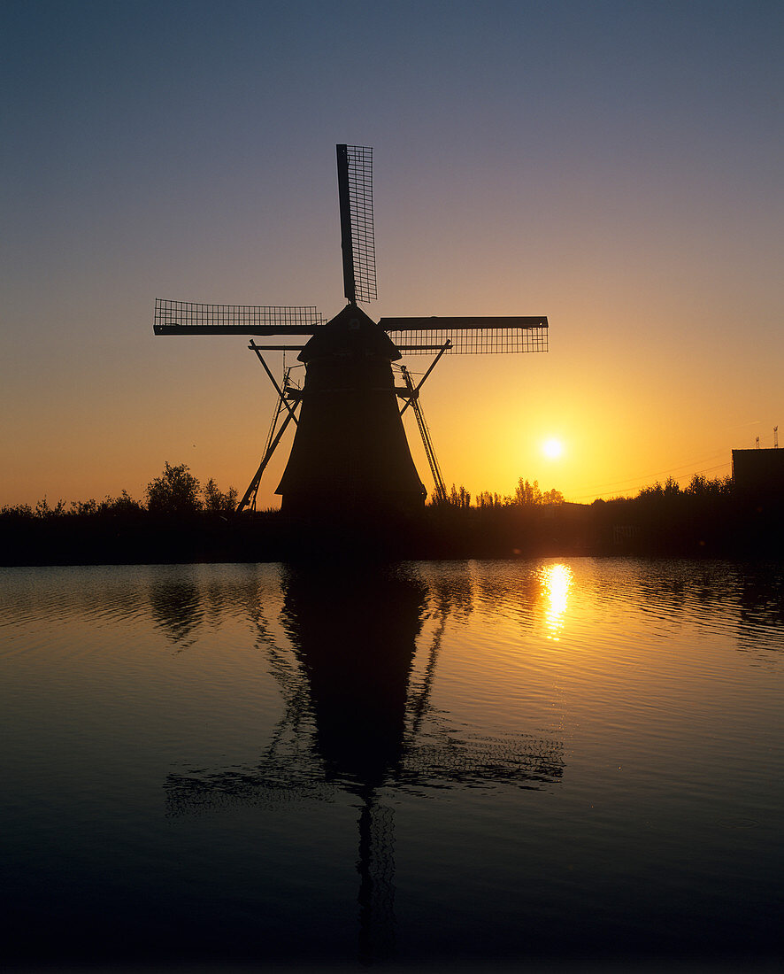 Sun rising behind a windmill