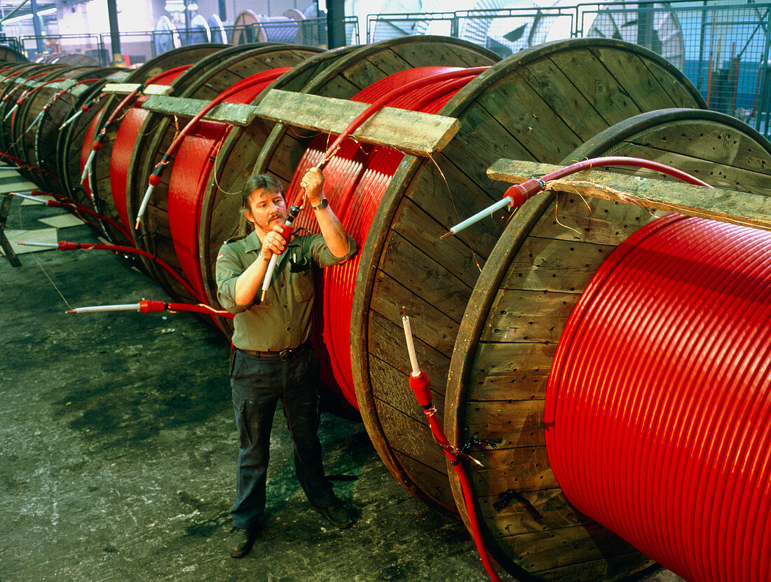 Worker tests reels of electric cable