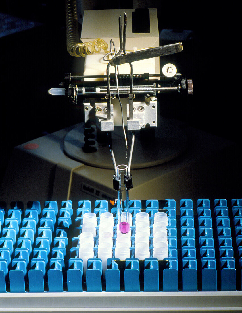 Robot arm manipulating samples in test tubes