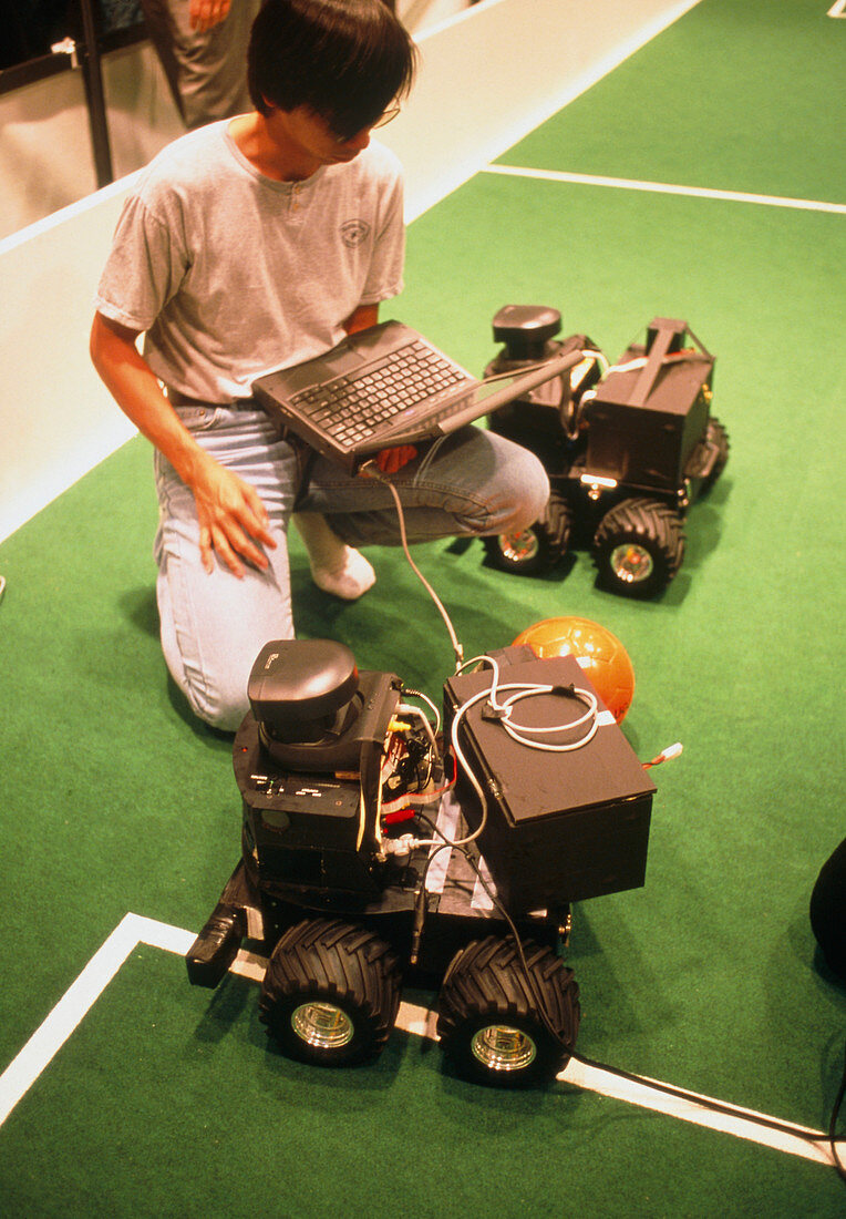 Technician programs robot at RoboCup-98