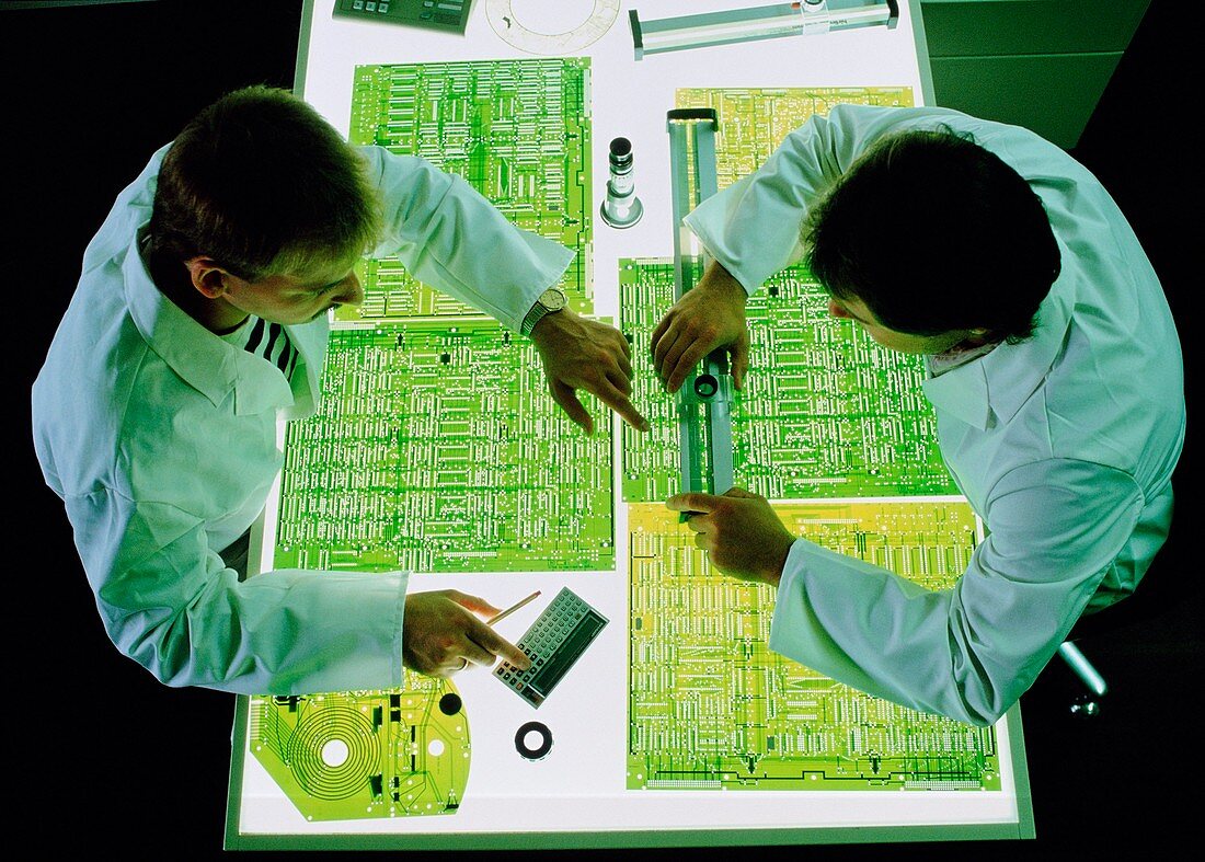 Technicians discussing printed circuit design