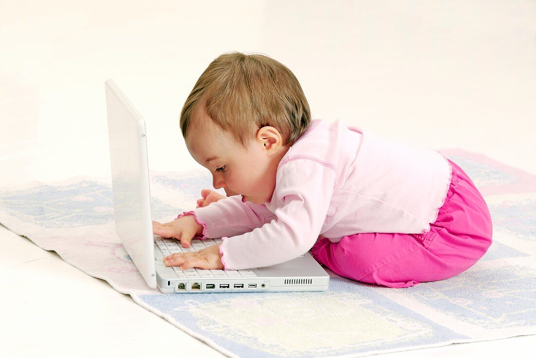 Baby playing with a laptop computer