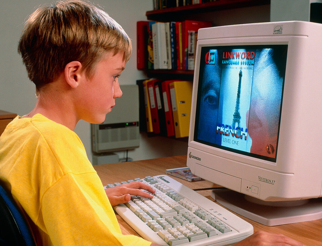 Boy using a multimedia computer to learn French