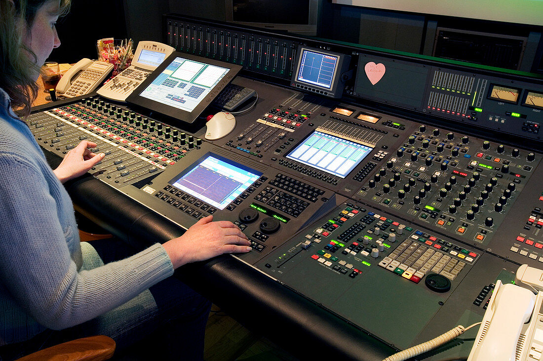 Technician operating audio mixing desk