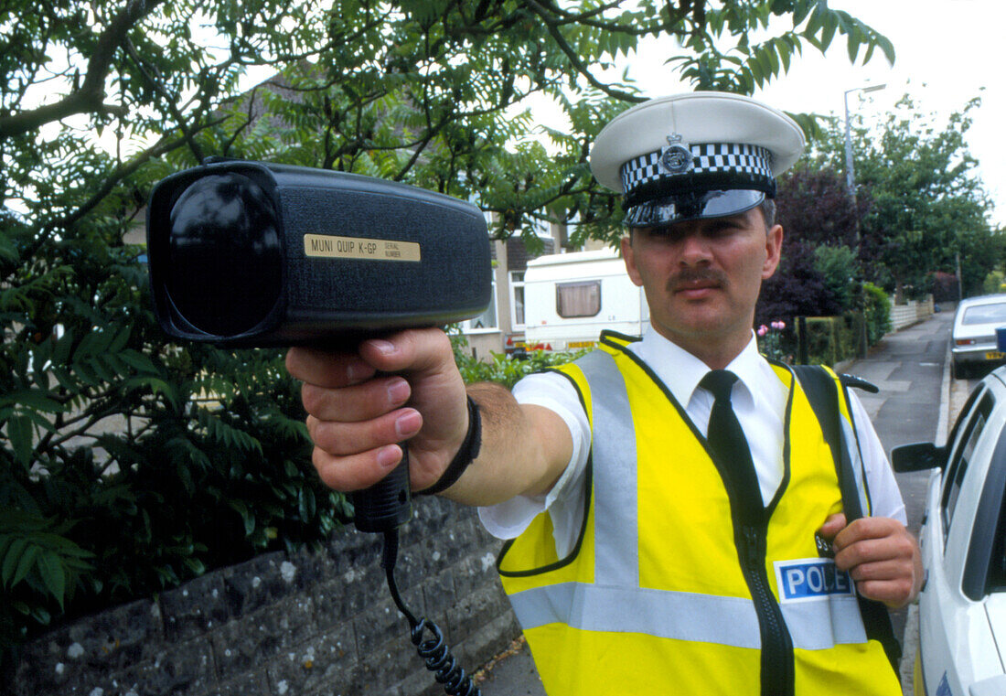 Policeman using radar gun to detect speeding car