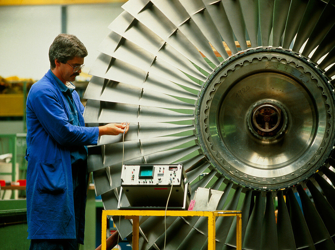 Technician testing aircraft engine turbine blades