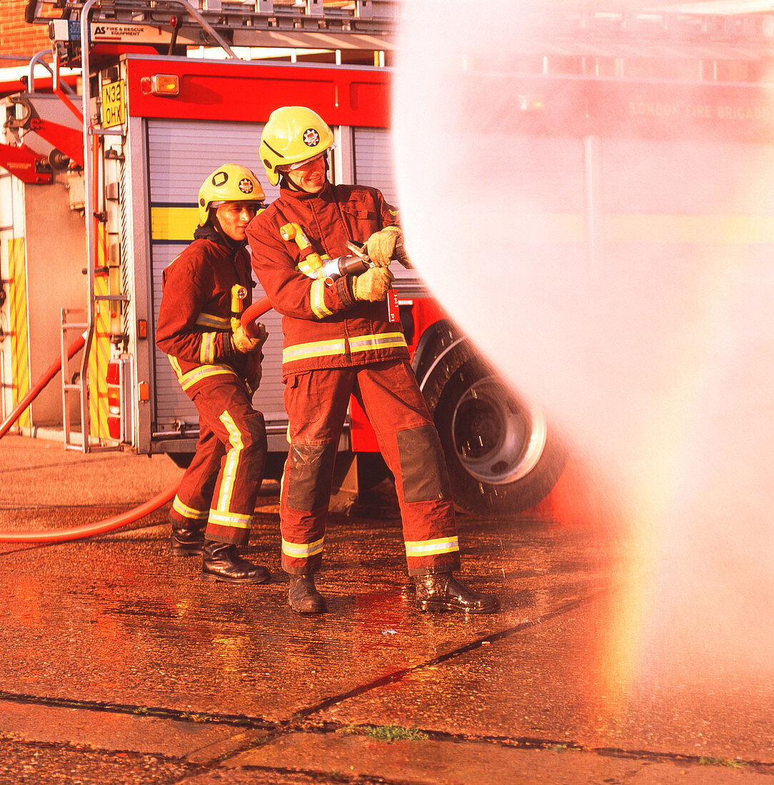 Firefighters using hose