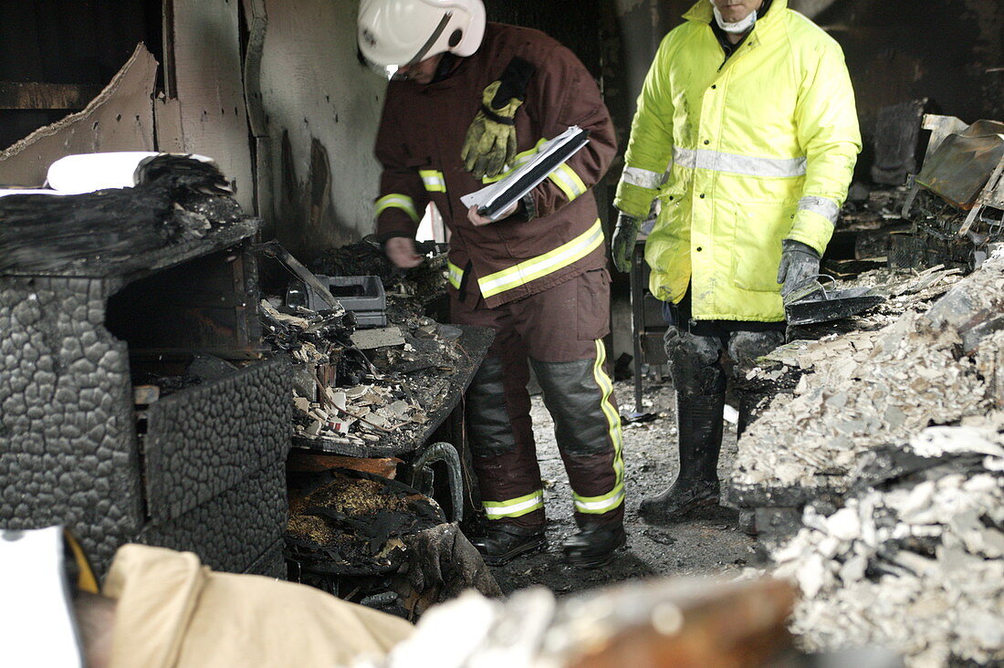 Firefighters in a burnt-out house