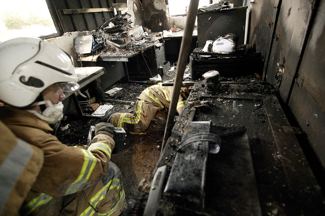 Firefighters in a burnt-out house