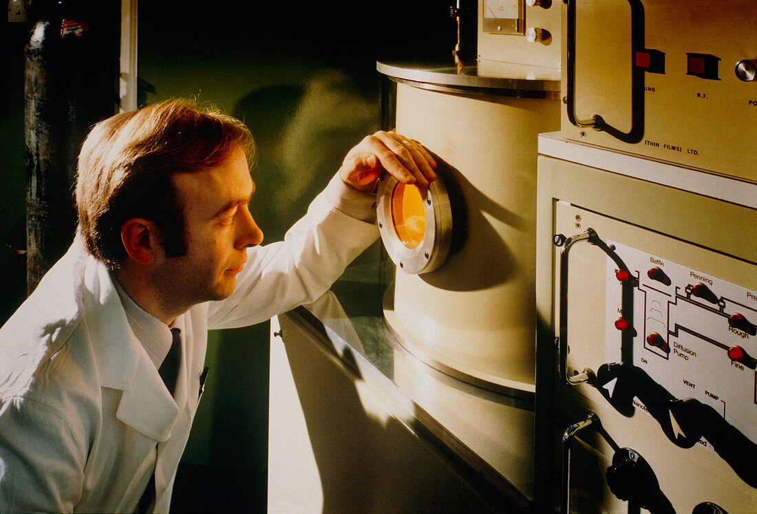 Technician views an ion plating chamber