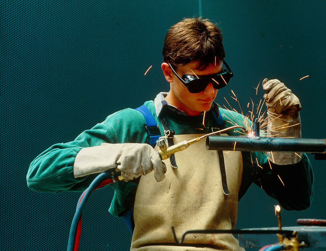 Man welding a pipe using an oxyacetylene torch