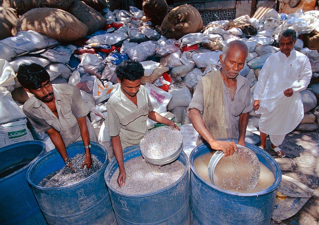 Men sorting plastic waste to separate out PVC