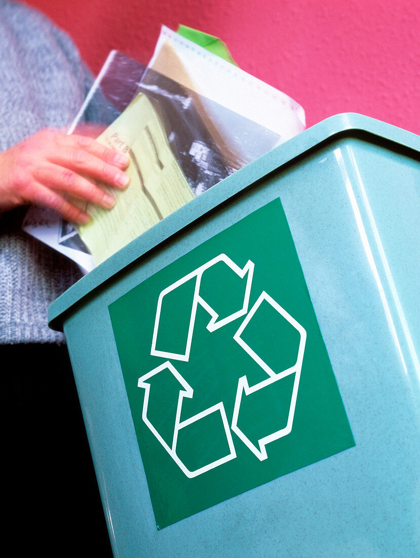 Person placing paper in a recycling bin