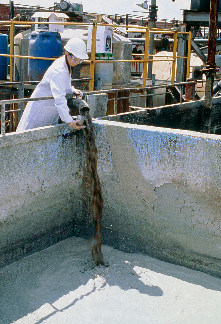 Chemist sampling chemical waste for toxicity