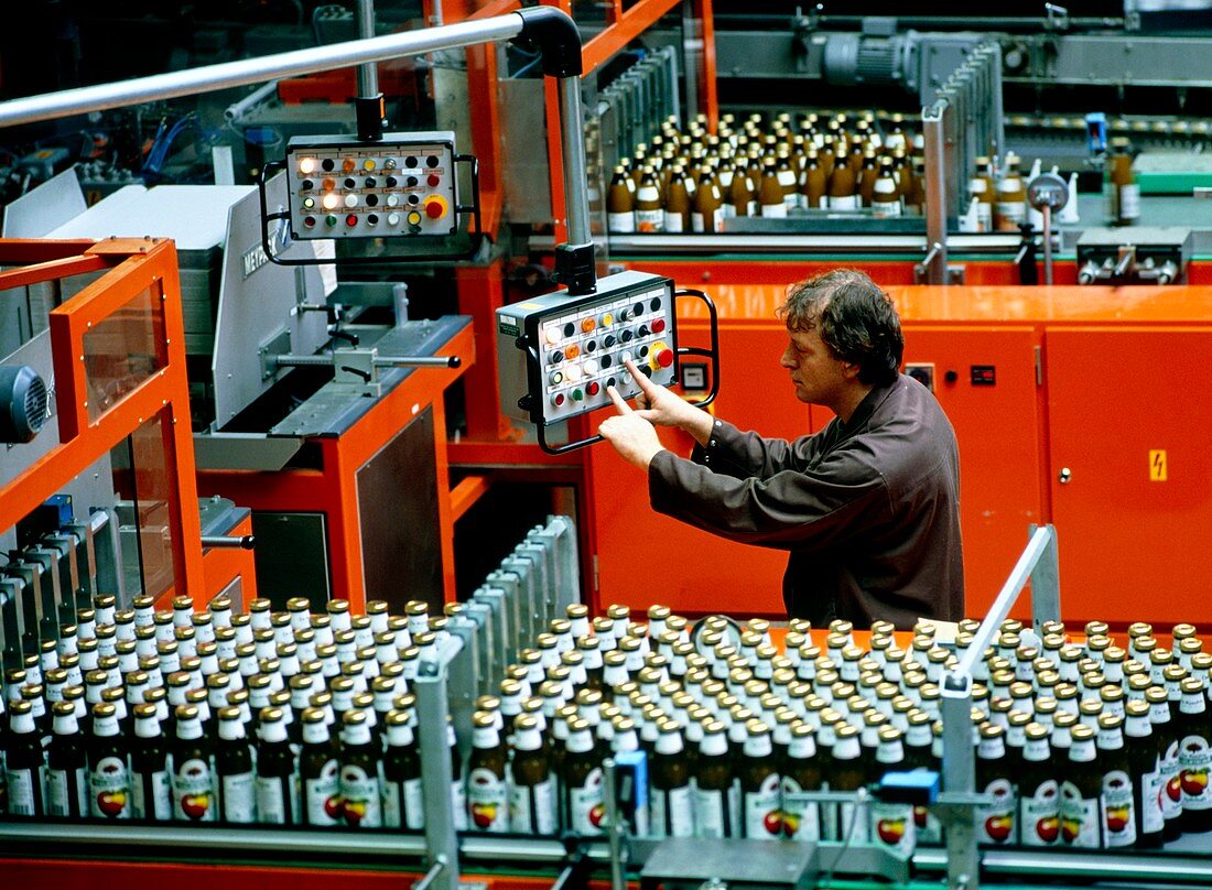 Worker on an apple juice bottling line