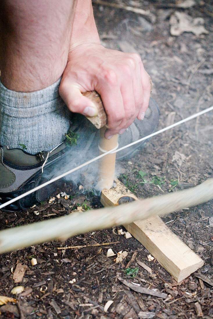 Making fire with a Bow Drill