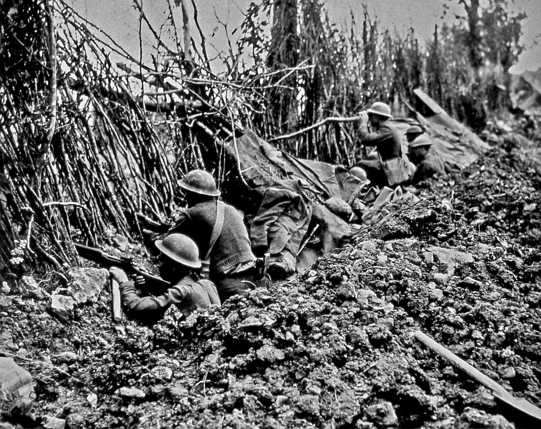 Infantry peering over the top of a trench