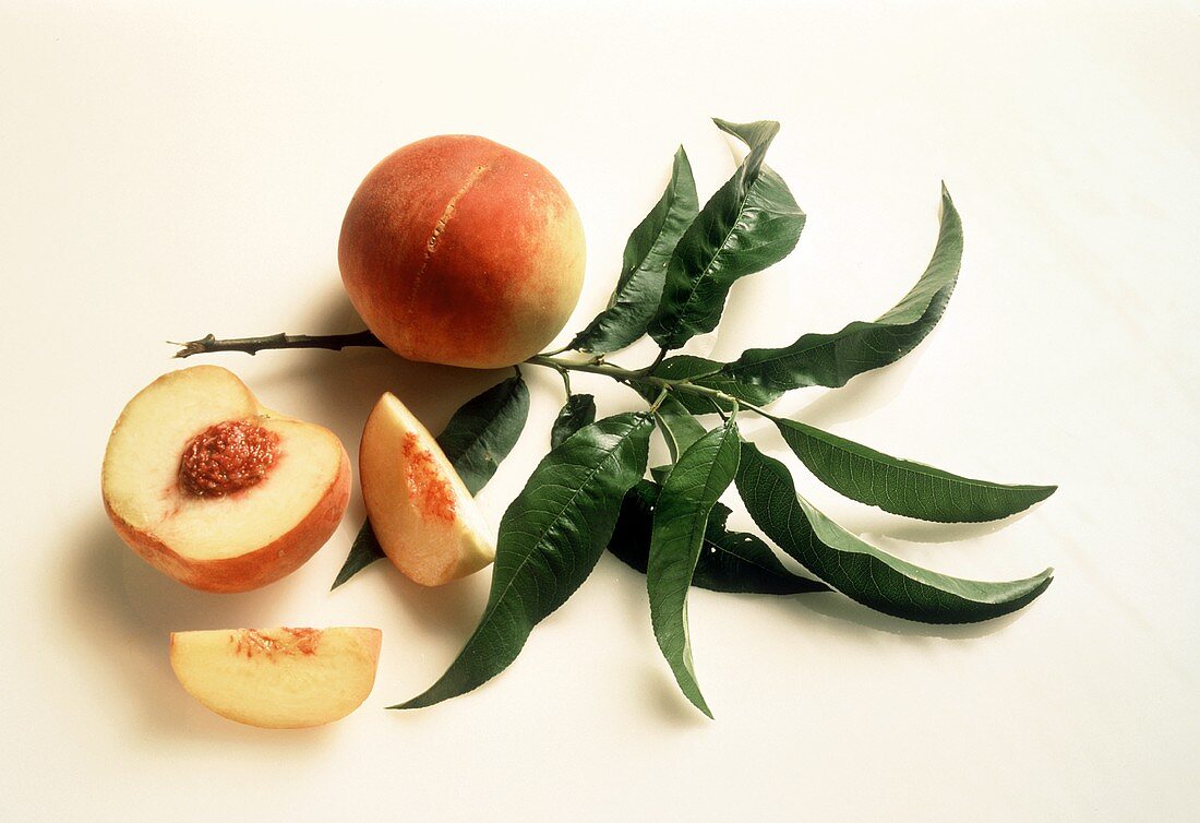 Whole Peach and a Sliced Peach with Peach Leaves