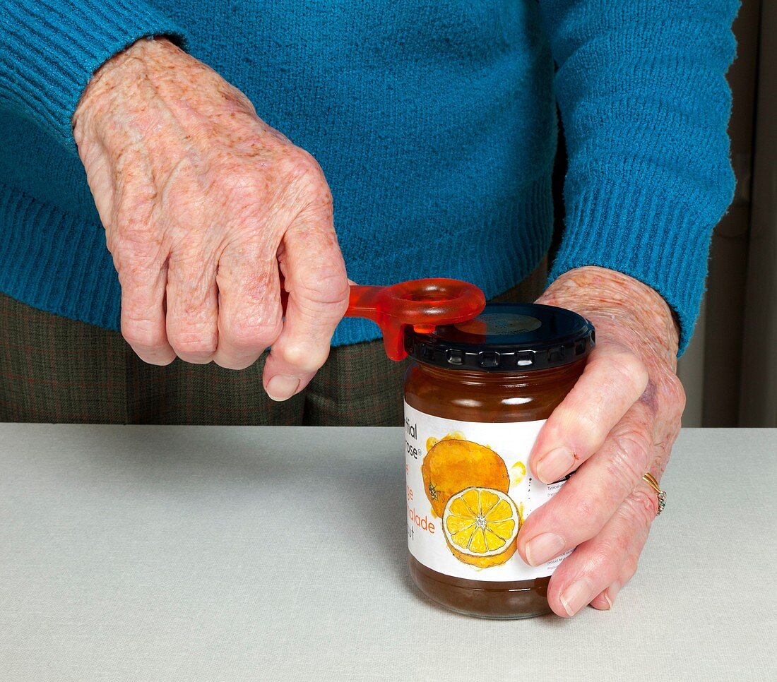 Elderly woman opening a jar