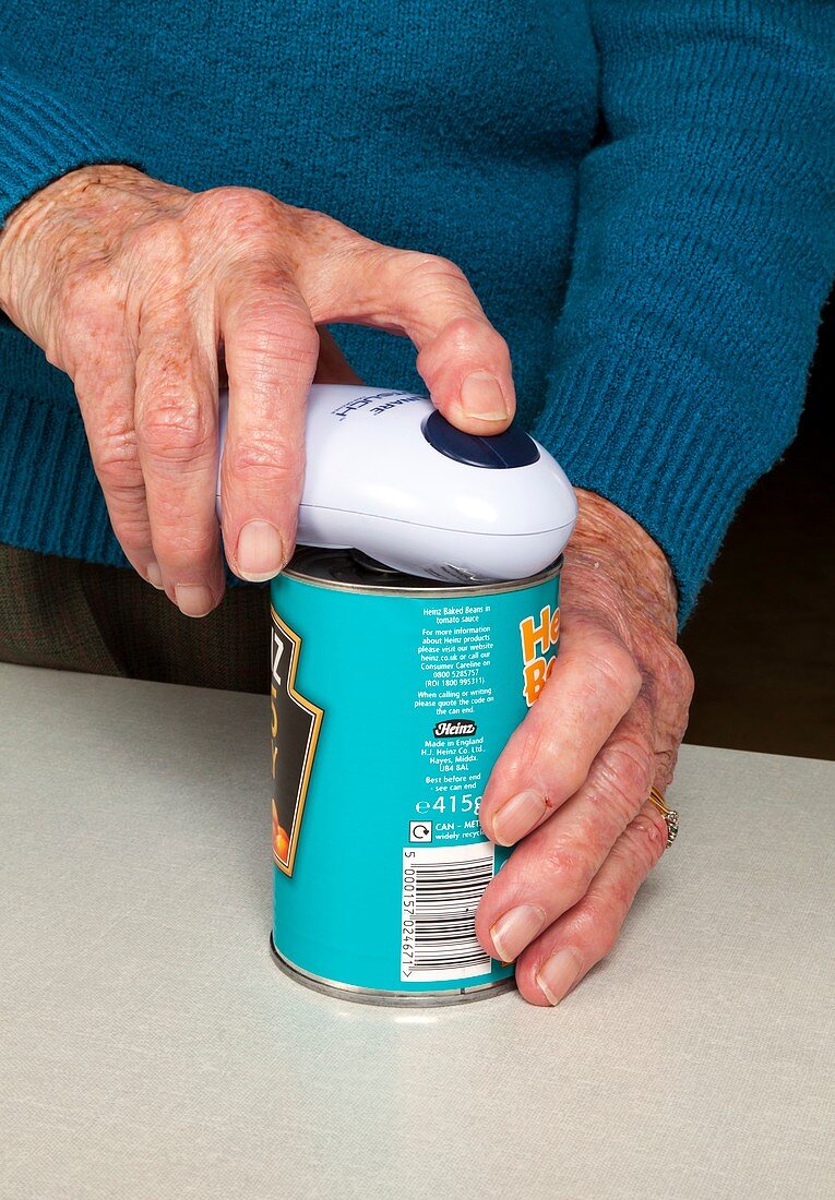 Elderly woman opening a tin