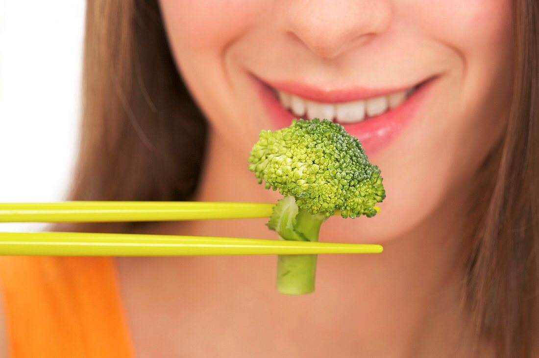 Woman eating broccoli