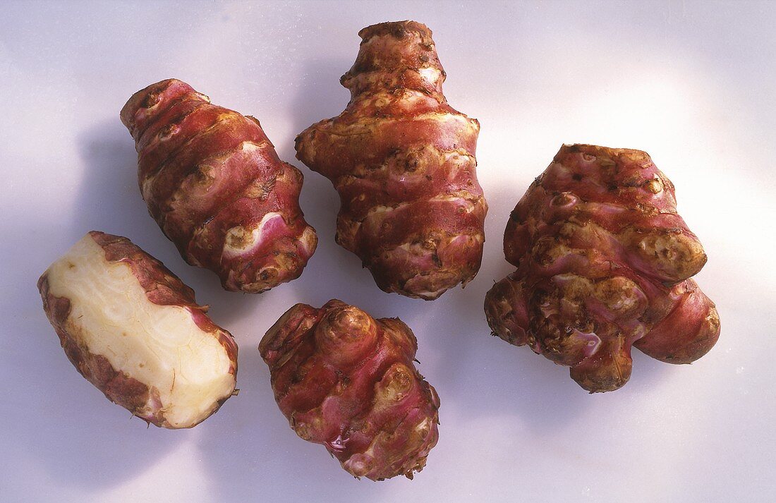 Five Jerusalem Artichokes; One Partially Peeled