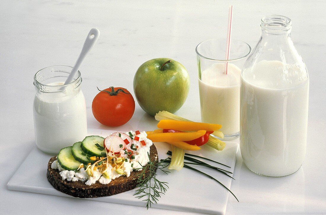 Milchprodukten-Stillleben mit Joghurt, Milch, Apfel, Tomate