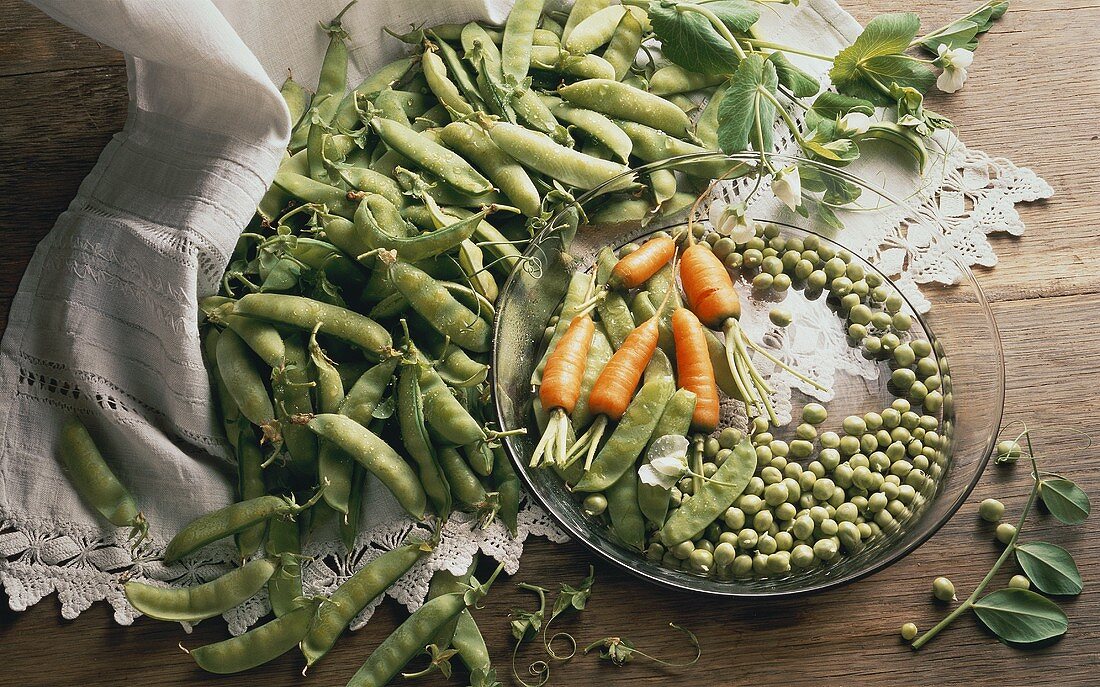 Several Pea Pods with Peas and Carrots
