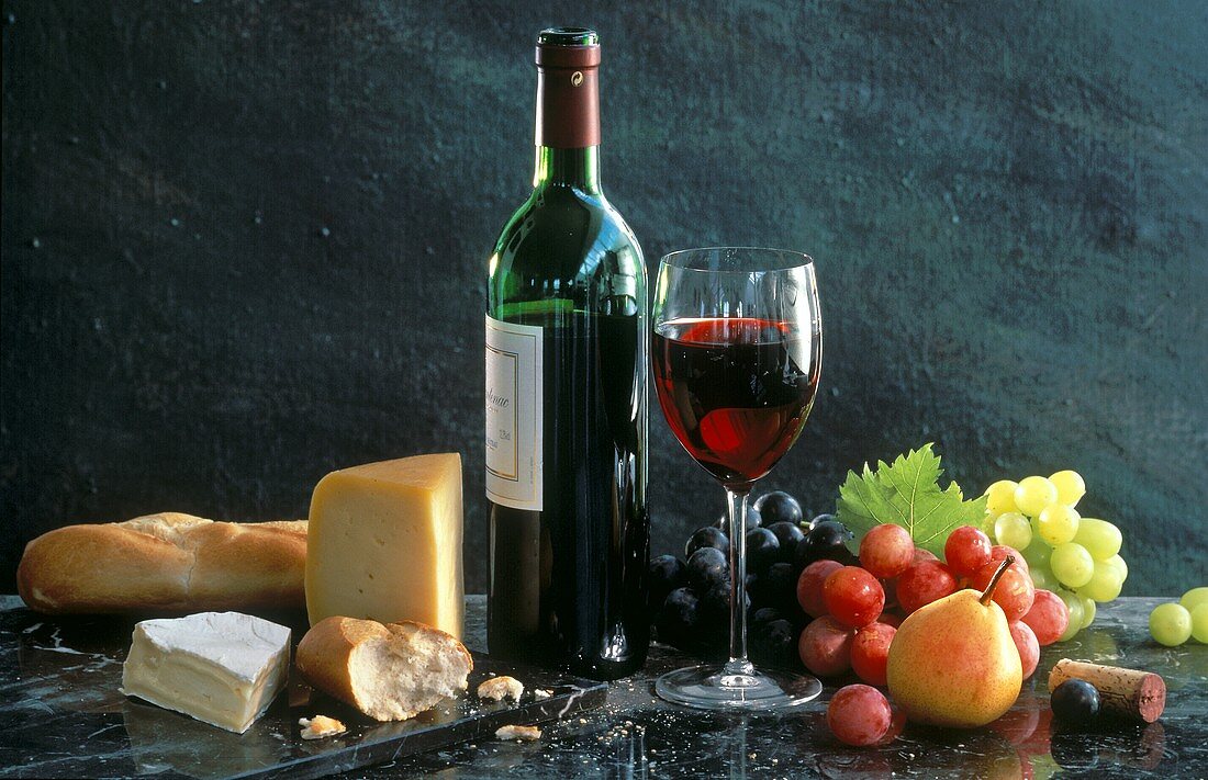 Rotweinstilleben mit Käse, Obst und Baguette