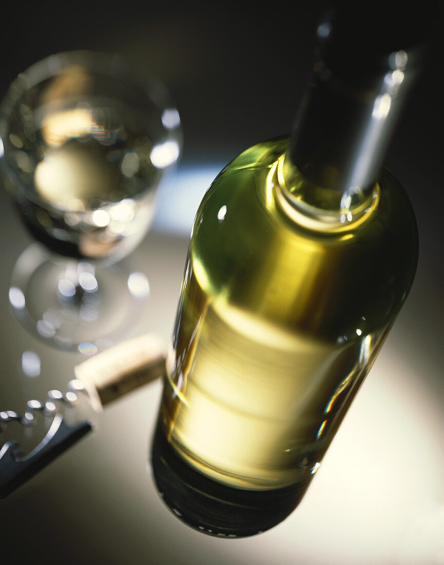 Weißweinstilleben mit Flasche, Glas und Korkenzieher