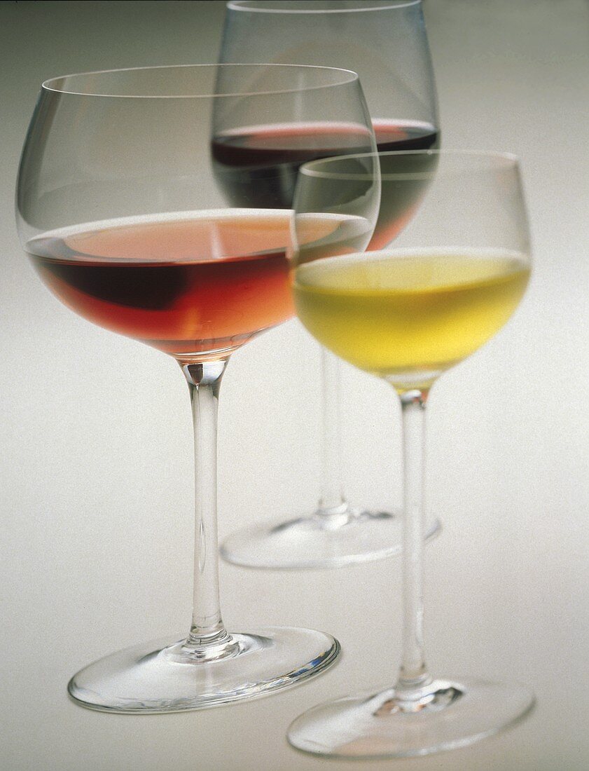 Drei Gläser hintereinander mit Weißwein, Rose und Rotwein