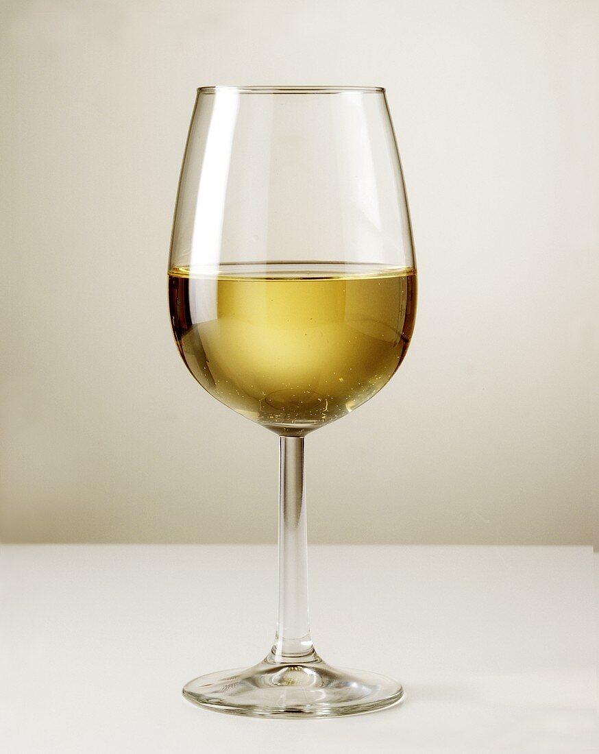 A half-full glass of white wine 