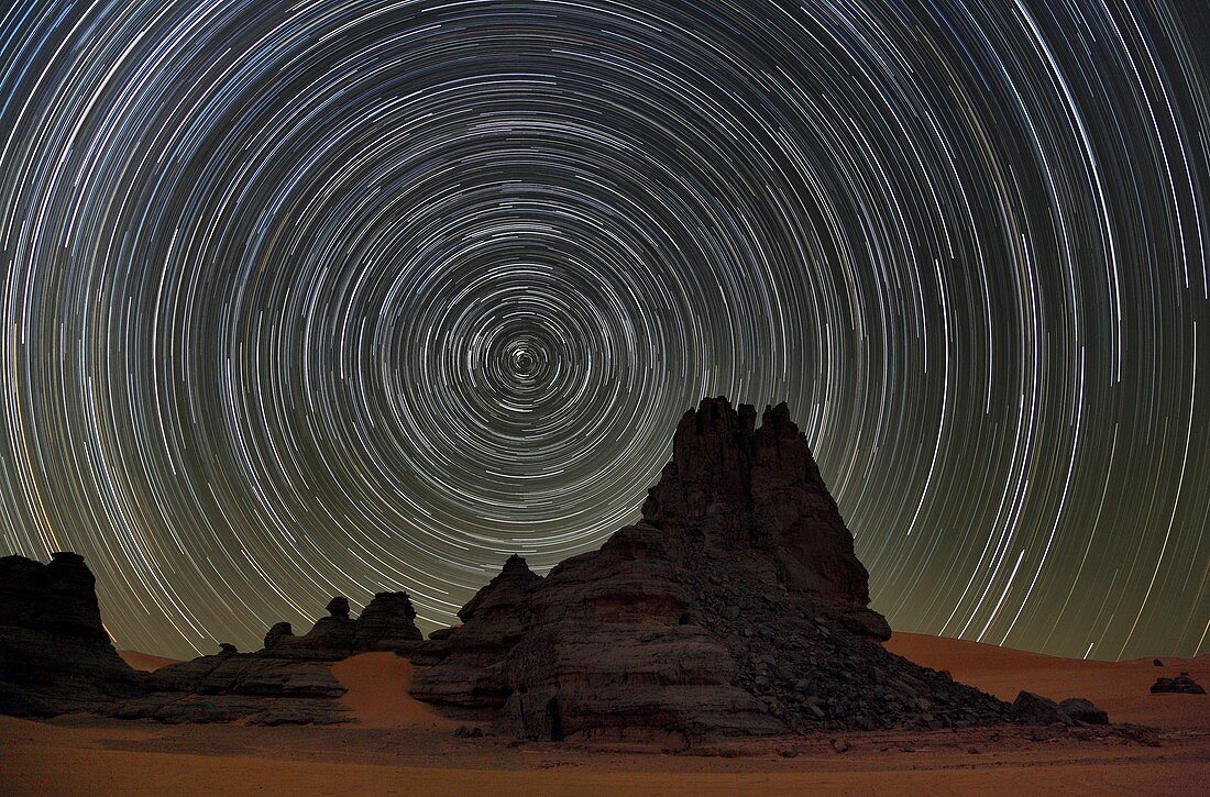 Star trails over Saharan rock formations