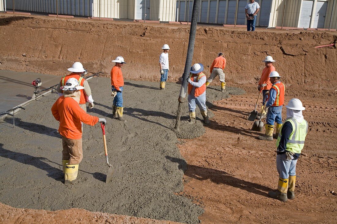 Workers lining a canal with concrete