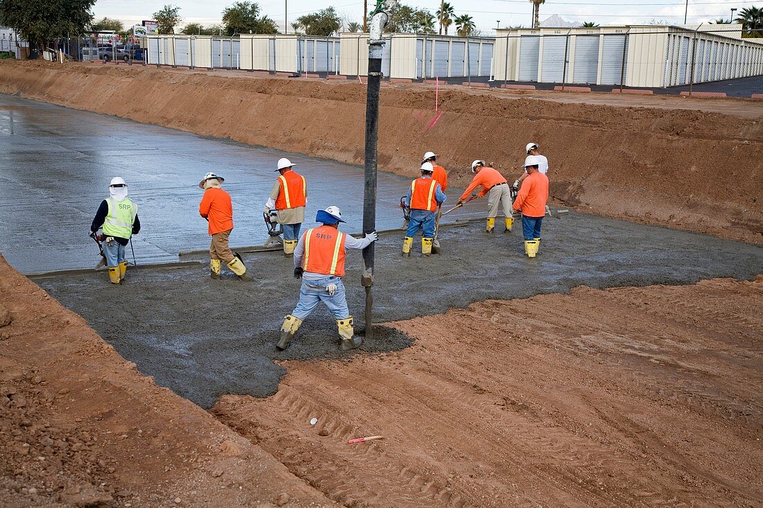 Workers lining a canal with concrete