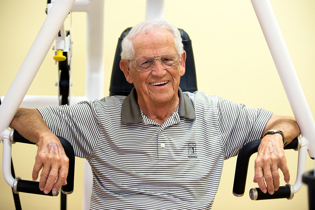 Active elderly man smiling in gym