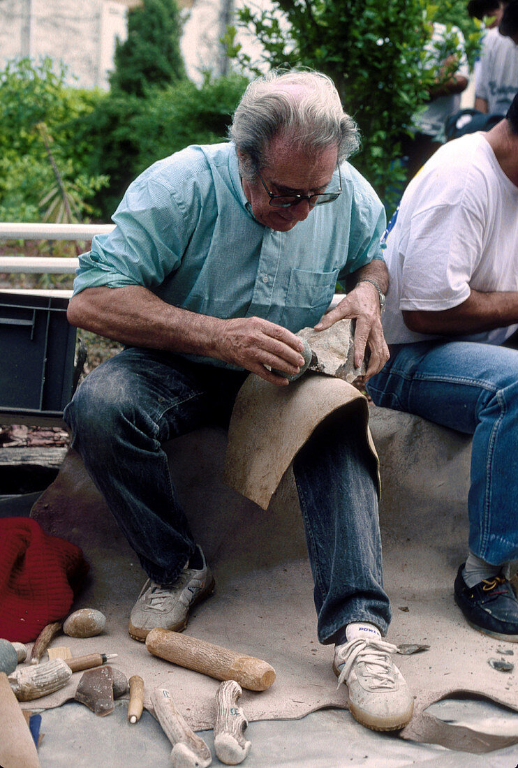 Archaeologist knapping flint stone tool