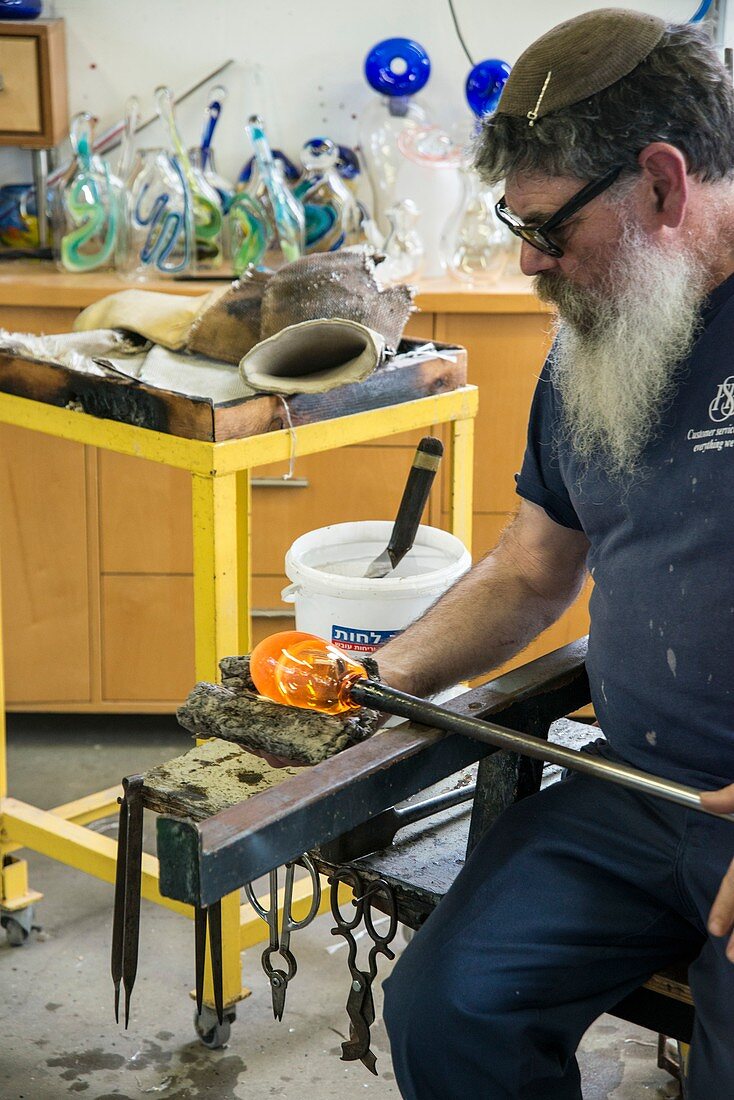 Glassblower forms molten glass