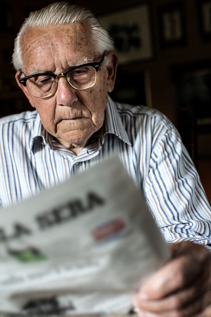 Elderly man reading a newspaper