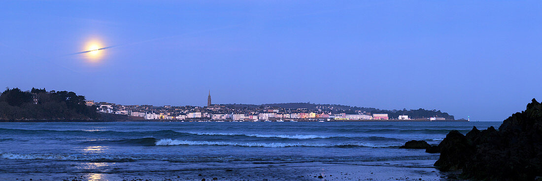 Full moon over coastal town