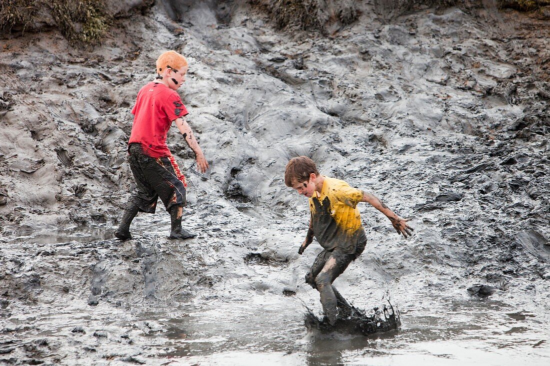Children playing in a muddy creek