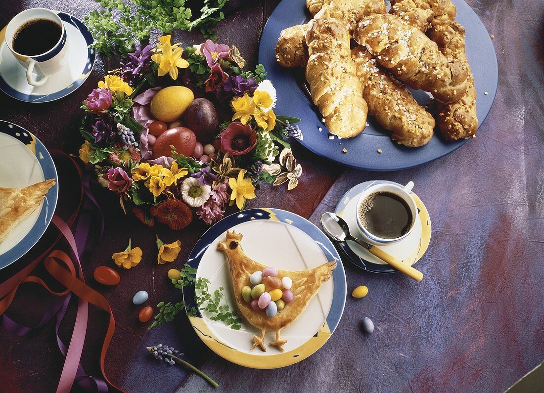 Blätterteighenne mit Zuckereiern auf bunter Ostertafel