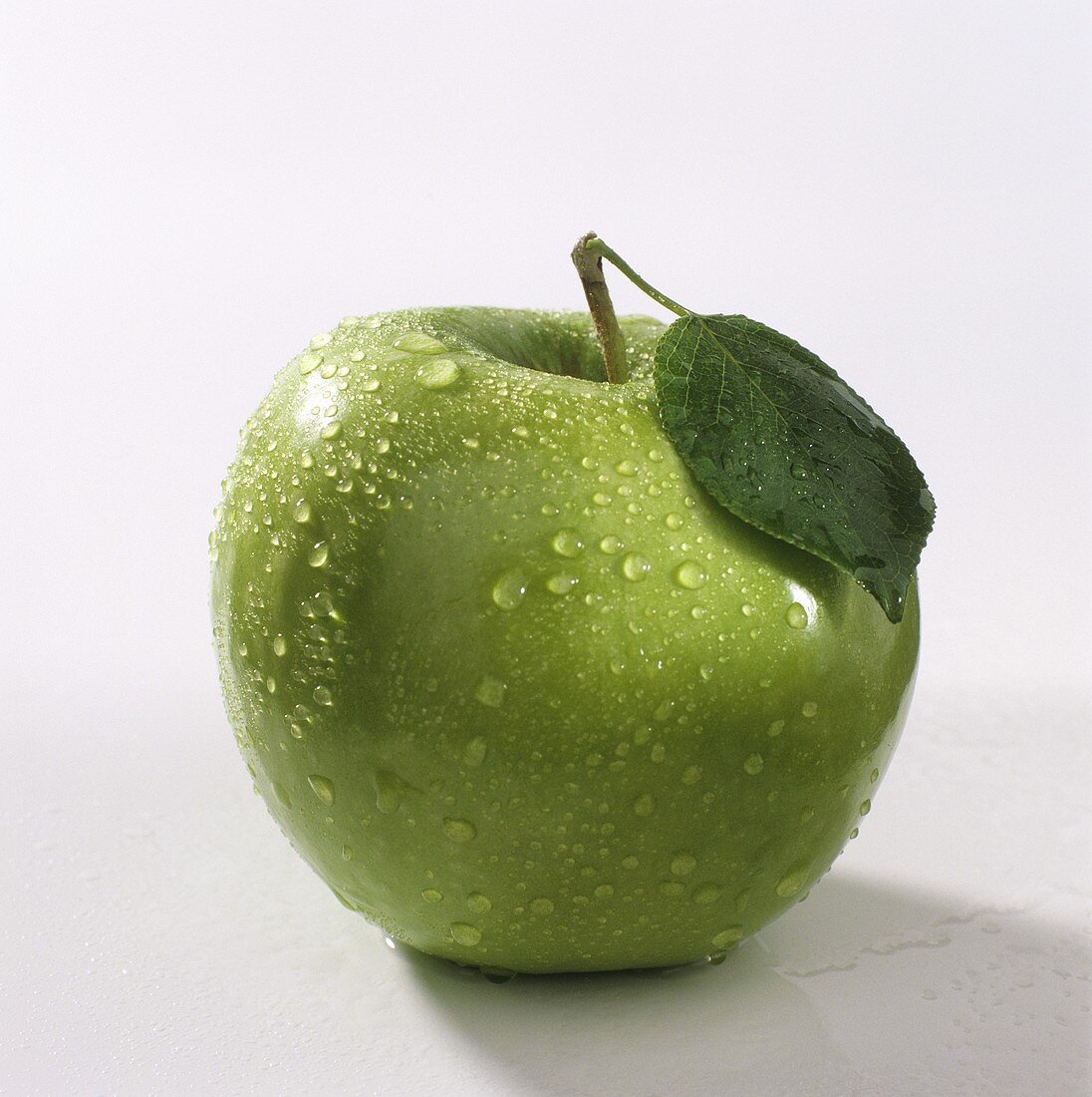 A Granny Smith with drops of water