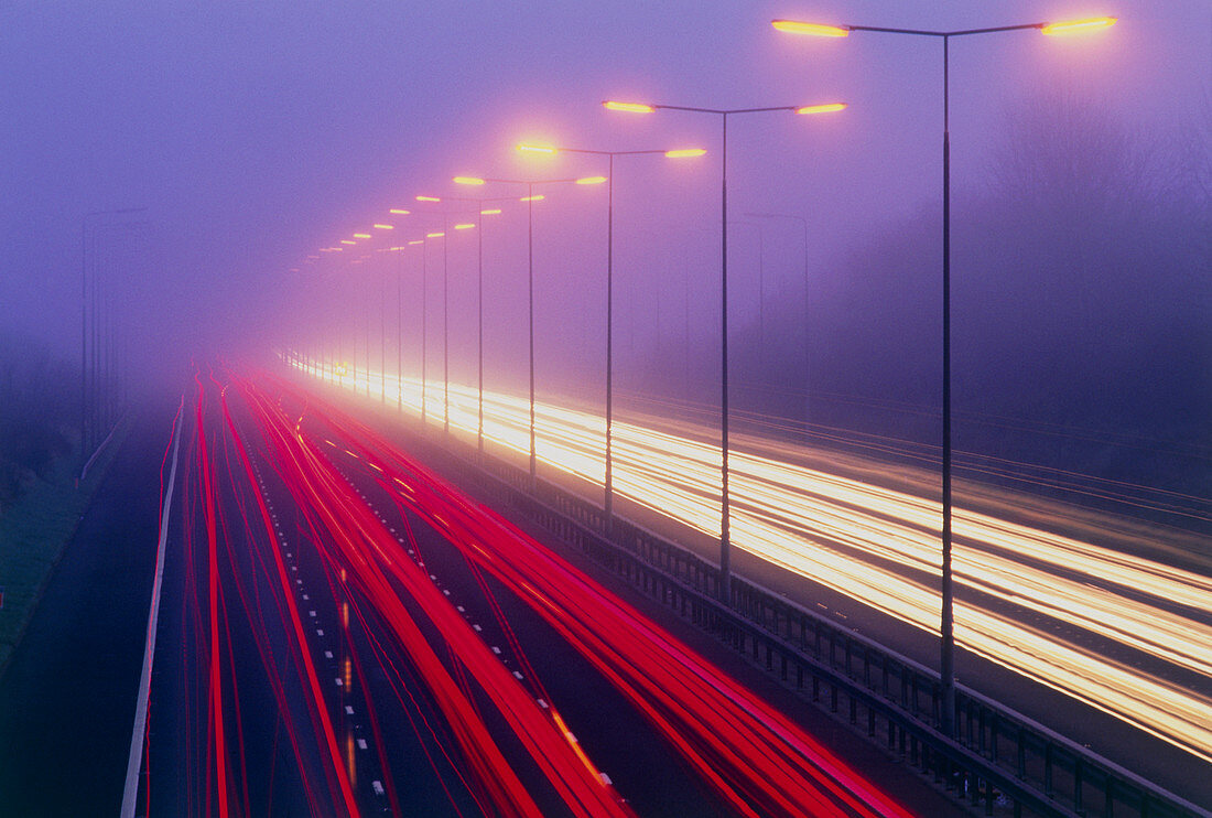 Time exposure image of car lights on a foggy road