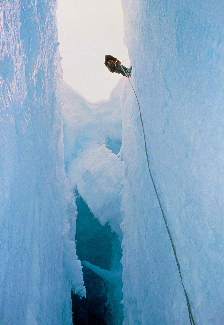Scientist climbing down into chasm,Antarctica