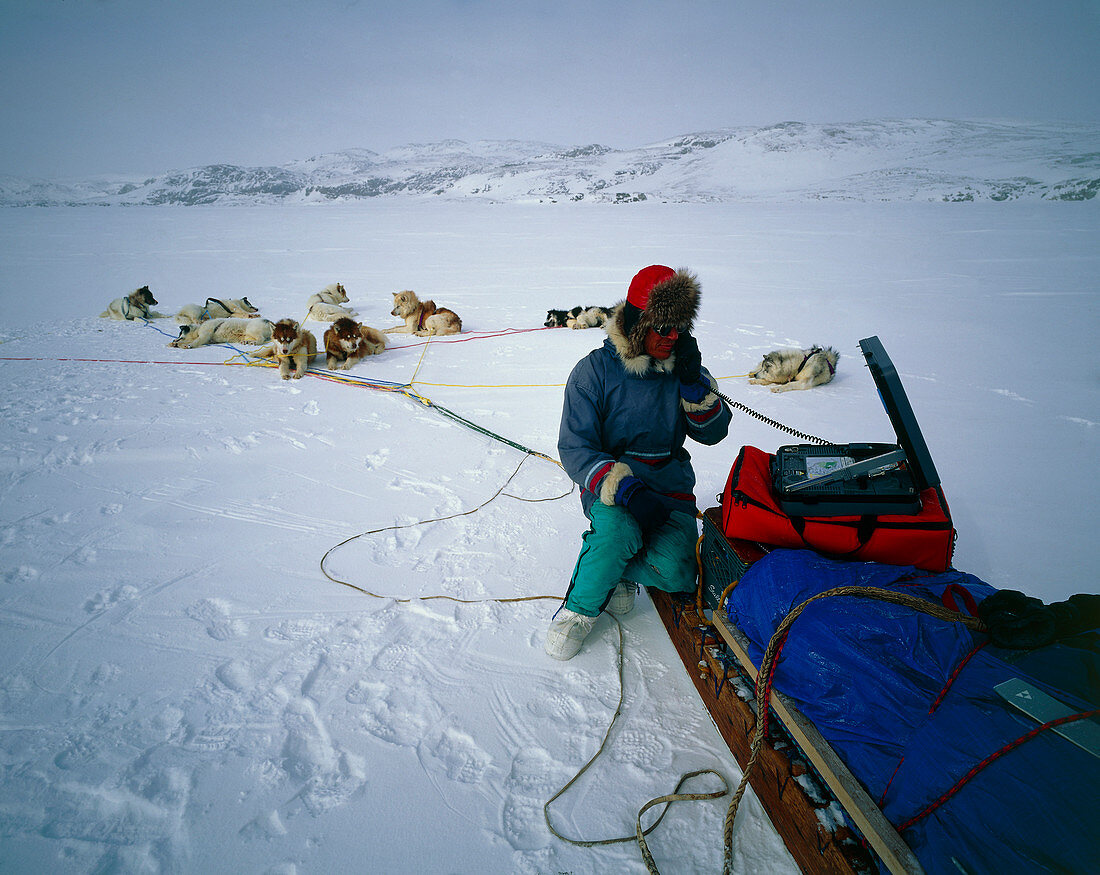 Dog sled driver resting on his sledge