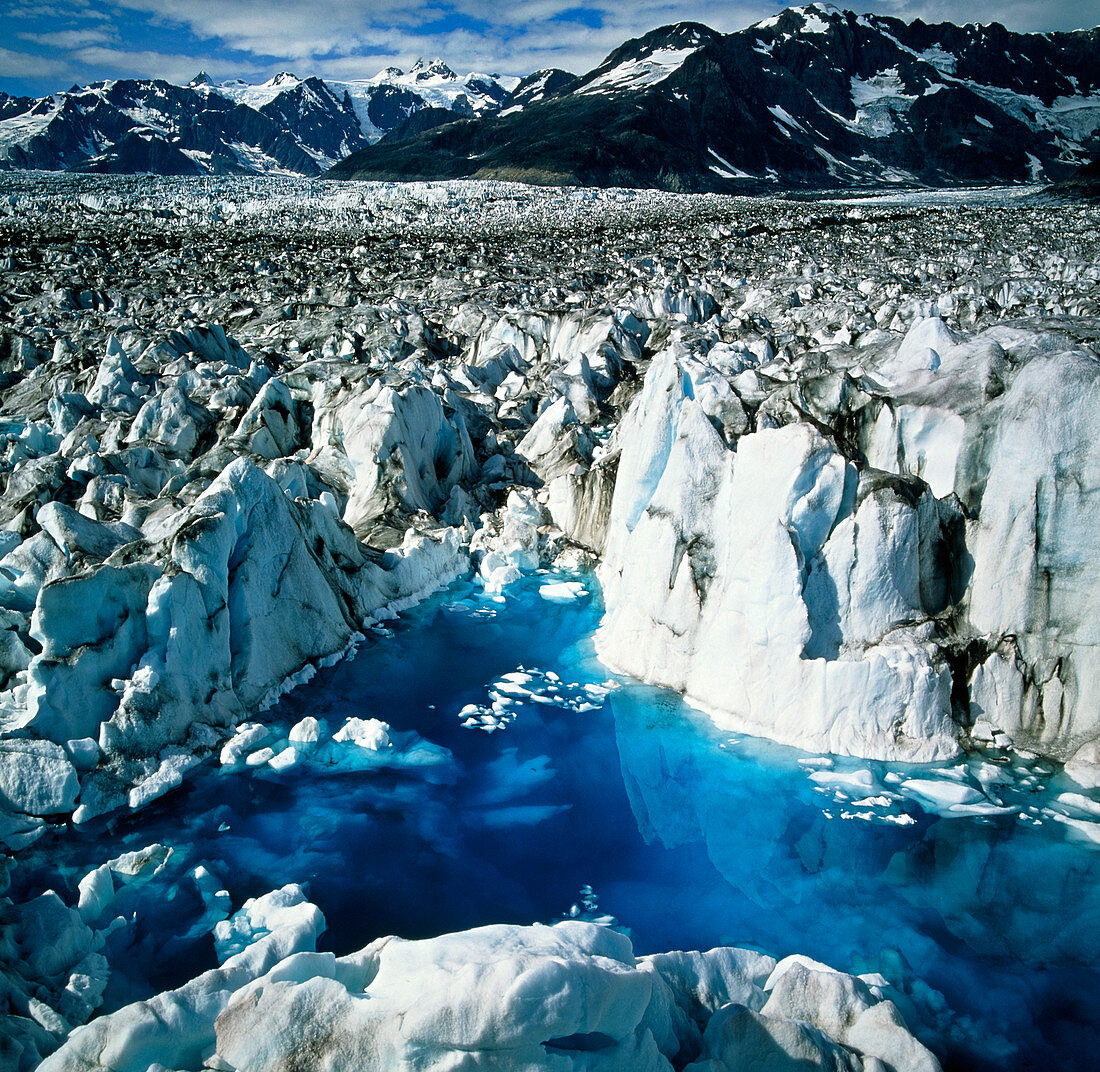 View of meltwater filling crevasses in a glacier