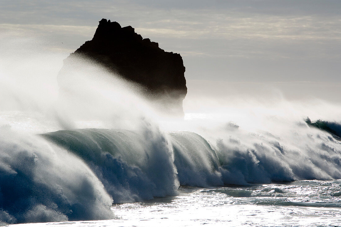 Waves crashing against basalt rock